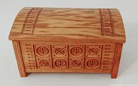Front view of carved wooden box with geometric motifs
