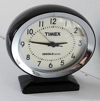 Front view of Timex Indiglo analog clock showing dial and bezel