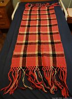 Full view of wool plaid shawl laid flat showing length and fringes