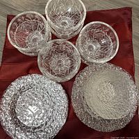 Group shot of textured plates and bowls on red cloth