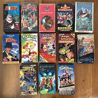 Front view of all 13 VHS tapes showing cover art