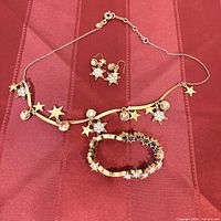 Necklace, earrings and bracelet overview on red background