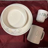 Bowl inside floral plate with mug and teacup visible