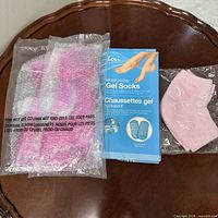 Boxed Lori gel socks and two sealed pink gel foot pads on table