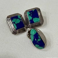 Front view showing two earrings and brooch displaying stone inlay