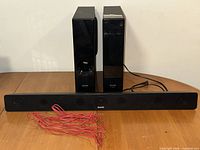 Front view showing sound bar, main unit, subwoofer, red wire