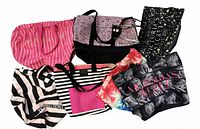 All seven Victoria's Secret bags laid out, front view showing prints and logos
