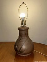Full view of brown ceramic gourd-shaped lamp lit