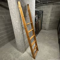 Full view of wooden bunk bed ladder leaning against wall