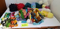 Overview of floss, tapestry wool skeins and knitting yarn balls on table