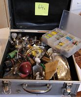 Overview of open metal case showing assorted bulbs, fuses, wiring and organizer box