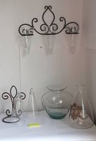 overall shot of metal sconces, glass cones, vase and decanter