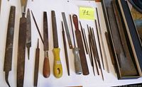 assorted steel files, rasps and chisels laid out on table