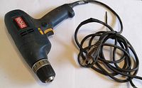 Full view of Ryobi corded drill with wrapped power cord
