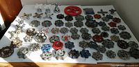 Full lot overview of 67 mixed metal valve handles spread on white surface