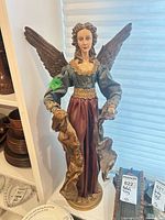 Full view of resin angel figurine standing on base