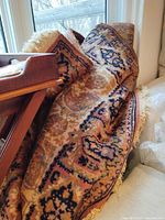 Rolled oriental-style rug with fringe showing overall pattern