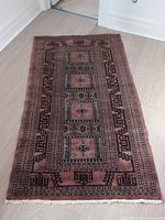 Full view of oriental-style area rug showing entire pattern and fringe