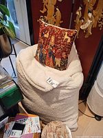 Bean bag with decorative pillow placed on top, tag visible