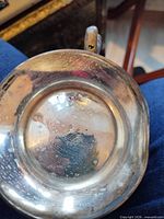 Underside of silver-tone dish showing tarnish