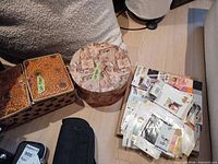 Overall lot showing sewing basket, round box and stack of scrapbooking supplies