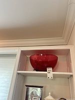 cranberry glass bowl on shelf front view