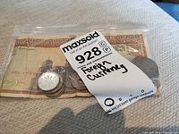 Bag containing assorted coins and Egyptian pound note