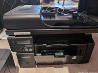 Left side view of HP LaserJet Pro M1130/M1210 printer with power cord on scanner lid