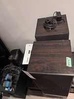 Top view of two Boston Acoustics floor speakers with cables and smaller speaker visible