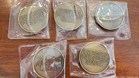 Five bronze Ready Player One coins in sleeves front view