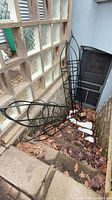 All four black plastic obelisk trellises on outdoor stairway