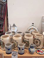 Full lot showing large and small steins, lidded stein, and flask
