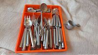 Full tray of pewter-handled flatware with separate measuring cup