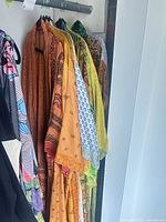 Nine patterned robes on rack, showing prints and colours