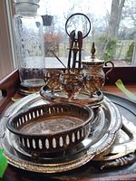 Group shot showing trays, pierced dish, egg cup stand with cups and spoons, creamer, glass carafe