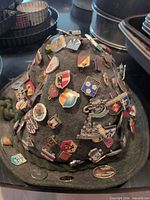 Full view of alpine hat covered with shield pins