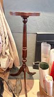 Full view of mahogany pedestal plant stand showing top, column, and feet