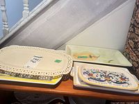 Stack of platters showing white pierced-edge platter, green Aurora platter, Deruta handled platter and others