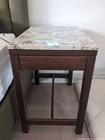 Three-quarter view showing full table beside bed