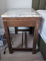 Full view of wood side table with granite top