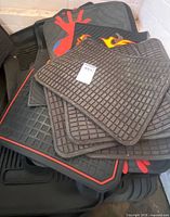 Stack of various rubber mats showing grid pattern, red Spider-Man graphic, flame motif