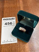 Ring in velvet presentation box next to lot tag