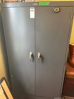 Front view of closed gray Cole-Steel cabinet with double doors and keyed handles