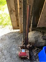 High-lift farm jack standing on ground with bottle jack at base
