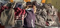 Group shot of all 13 folded sweaters on table