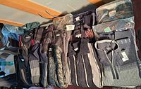 Fifteen folded sweaters, several in plastic packaging showing variety of styles and colors