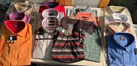 Tabletop view of all 15 packaged shirts showing variety of colors and styles