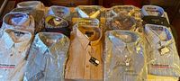 Sixteen packaged men's shirts laid out on table