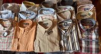 Eighteen folded shirts in three rows showing variety of colours and patterns