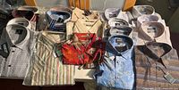 Tabletop view of 19 tagged men’s shirts showing variety of colours and patterns